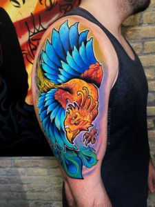 Tatuaje vibrante de un fénix a color estilo neotradicional en el antebrazo de una persona, mostrando una curación perfecta y colores saturados en el estudio Trip n Tattoo Barcelona