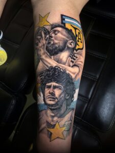 Messi and Maradona portrait leg tattoo with color AFA shield by Joni in Barcelona.