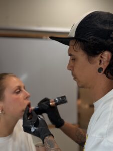Artista tatuando el interior del labio a una clienta en Trip n' Tattoo Barcelona Barrio Gótico